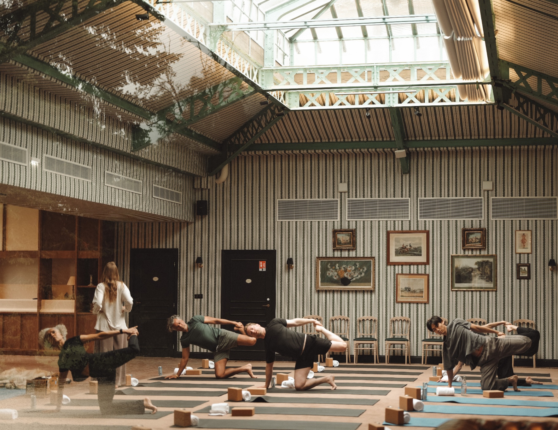 Odyssey guests in a morning yoga session beneath a glass roof.